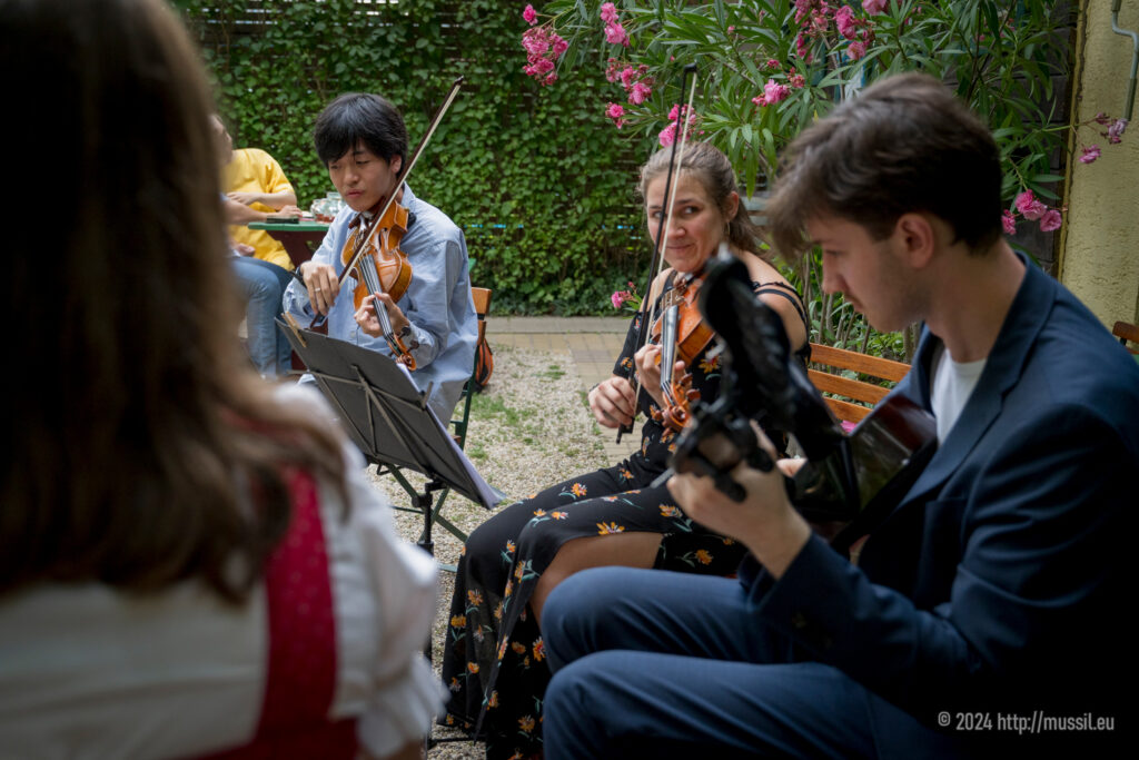 Naotaka Sato, Alenka Brecelj und Paul Seifried von NeuKlangSchrammeln beim Heurigen Hengl-Haselbrunner Wien, Juli 2024