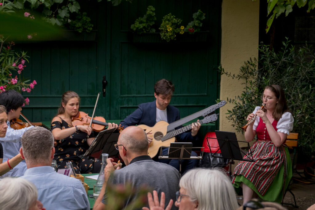 Naotaka Sato, Alenka Brecelj, Paul Seifried und Tanja Weiss von NeuKlangSchrammeln beim Heurigen Hengl-Haselbrunner Wien, Juli 2024